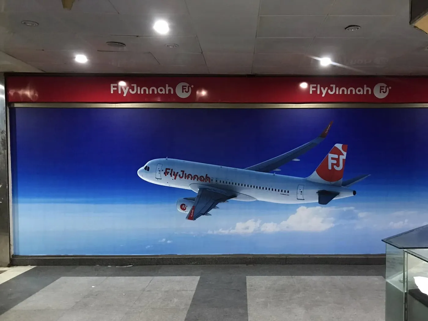 Fly Jinnah aircraft graphics printed across a glass shopfront